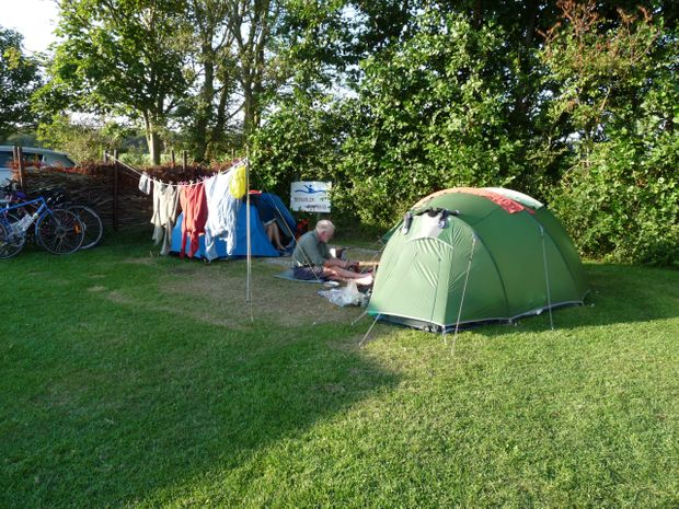 Tenten op het grasveld met een waslijn en fietsen ernaast
