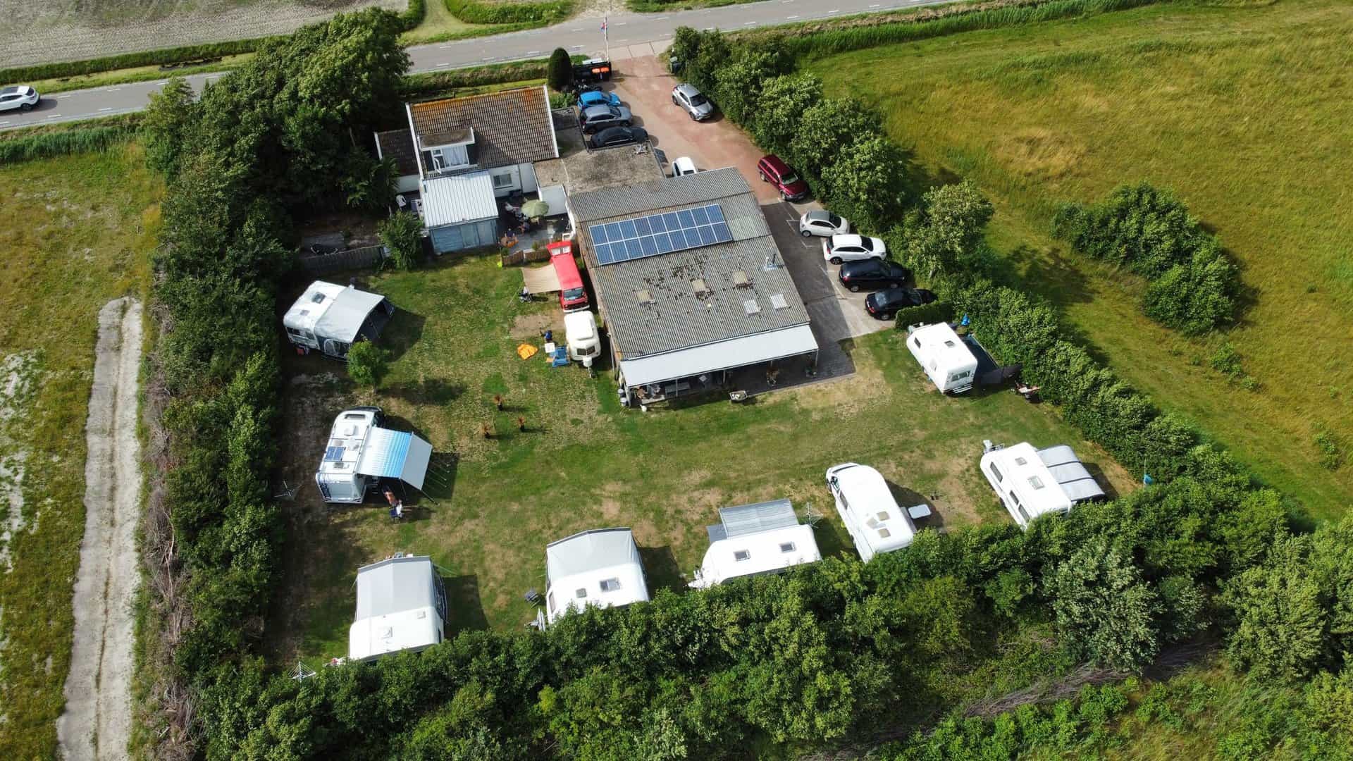 Luchtfoto van de minicamping met caravans rond het grasveld