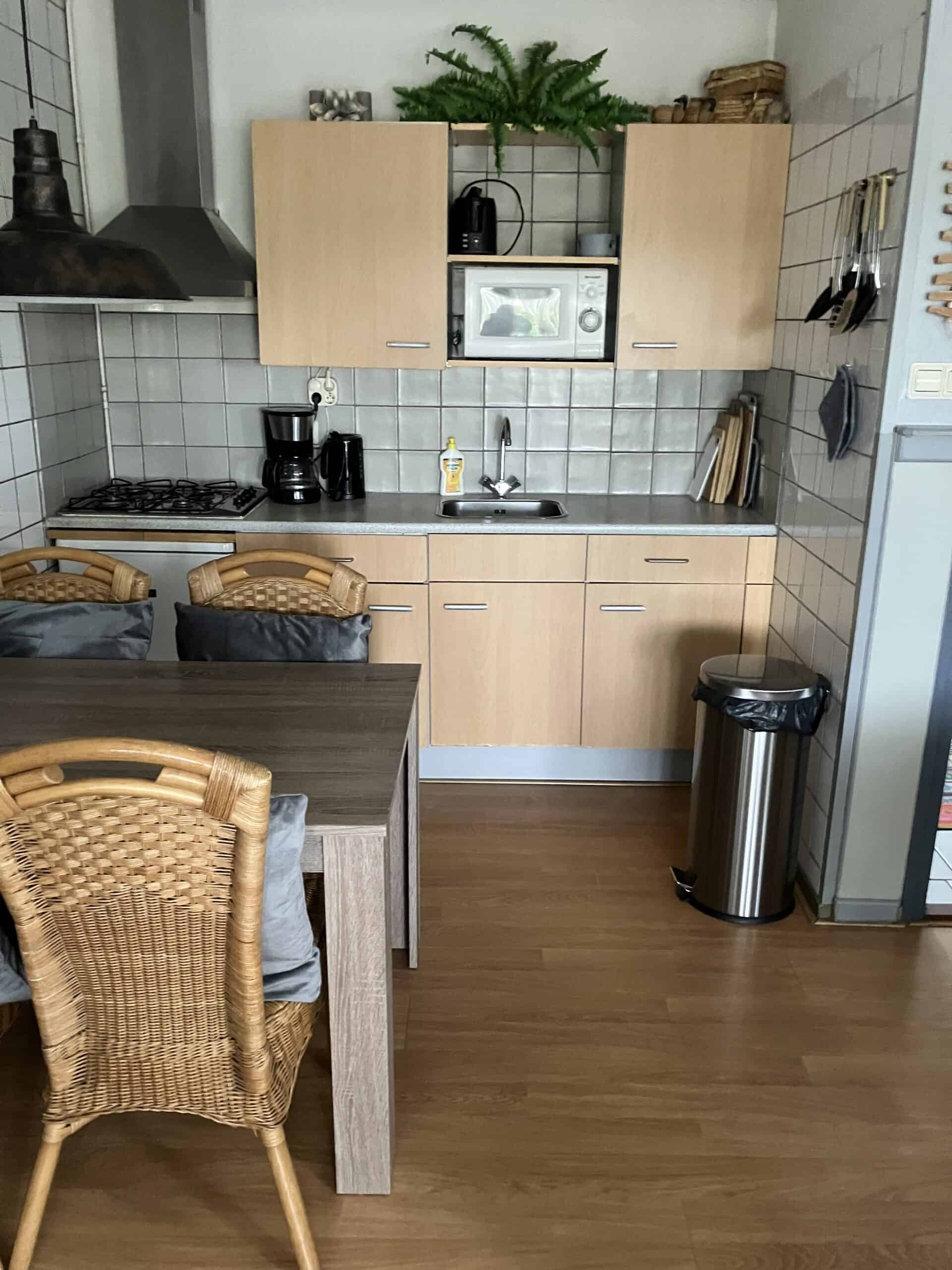 De keuken met gasfornuis, magnetron en eettafel